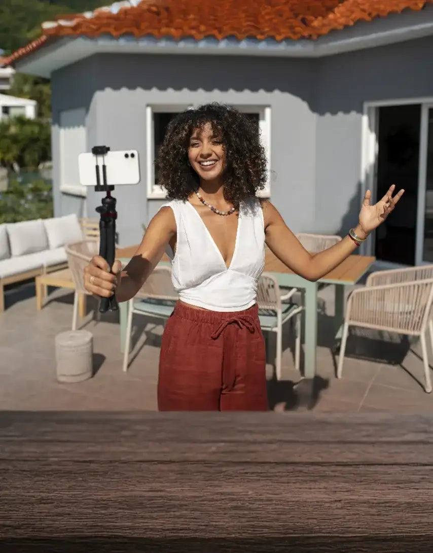 Black selfie stick with a white smartphone mounted on top.