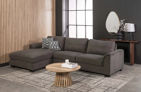 Gray fabric sectional sofa with a chaise lounge on the left side and two patterned throw pillows