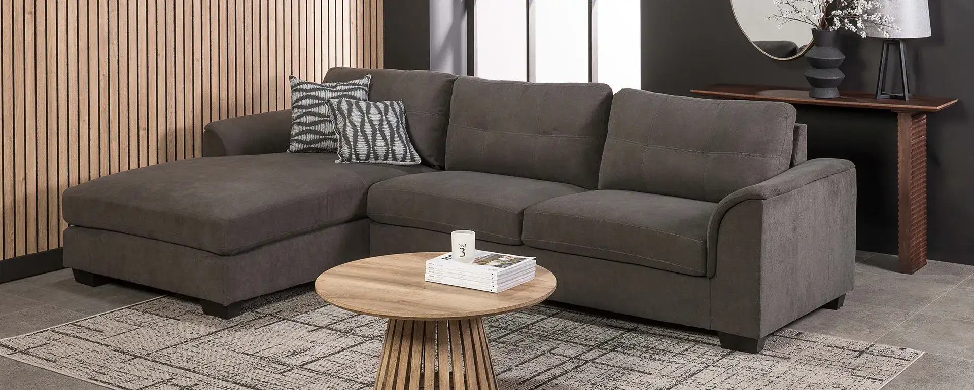 Gray fabric sectional sofa with a chaise lounge and patterned throw pillows
