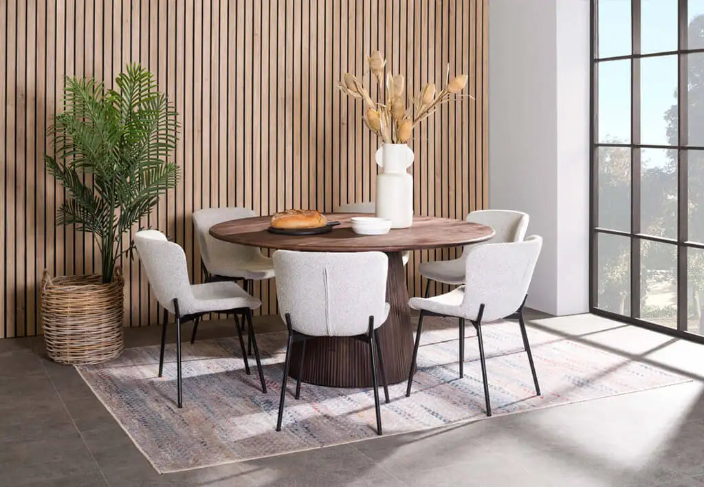 Round wooden dining table with a dark brown finish and a central pedestal base