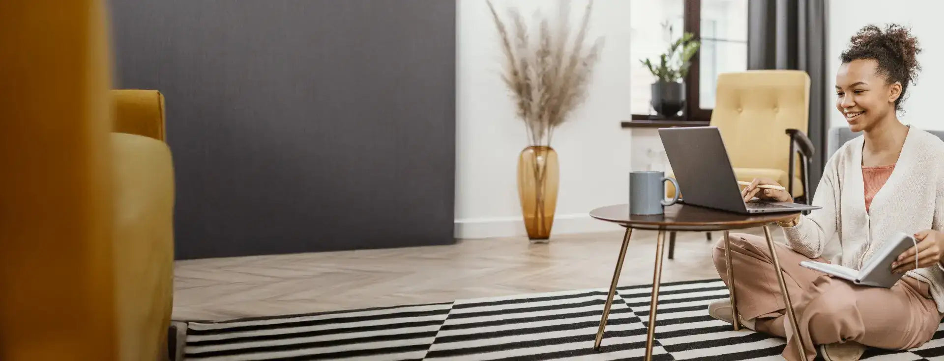 A sleek, dark gray laptop resting on a small round wooden table.